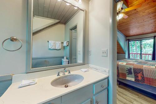La salle de bains est pourvue d'un lavabo, d'un miroir et d'un lit. dans l'établissement Hillcrest Lodge, à Pigeon Forge