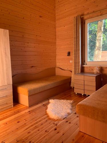a room with a bed in a wooden cabin at Pociunai relax house in Pociūnai