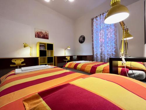 een slaapkamer met 2 bedden en kleurrijke dekens bij Apartment Platana in Rijeka