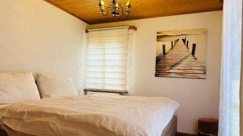 a bedroom with a bed and a painting on the wall at Casa do Lago in Leissigen