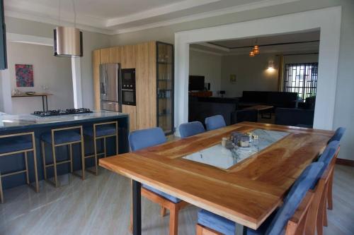 a kitchen with a wooden table and a dining room at Villa Nducha in Dar es Salaam