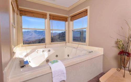 a white bathroom with a tub and windows at Sky High in Gatlinburg