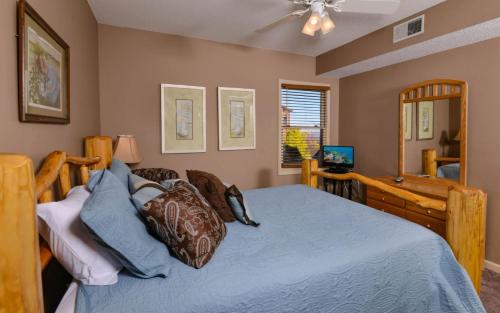 - une chambre avec un lit doté de draps bleus et d'un ventilateur dans l'établissement Sky High, à Gatlinburg