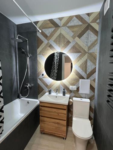 La salle de bains est pourvue d'un lavabo, de toilettes et d'un miroir. dans l'établissement Apartment Premium in center, à Ivano-Frankivsk