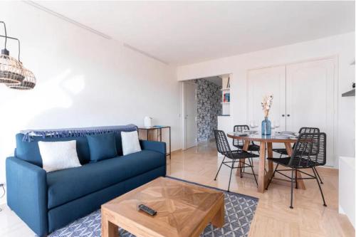 un salon avec un canapé bleu et une table dans l'établissement Cocoon with garden near the sea, à Cannes