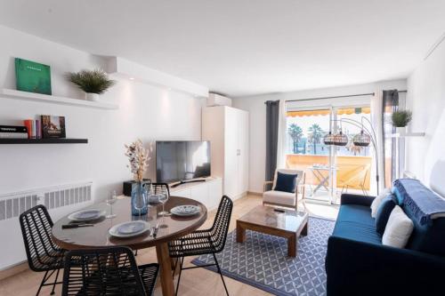 un salon avec une table et un canapé bleu dans l'établissement Cocoon with garden near the sea, à Cannes