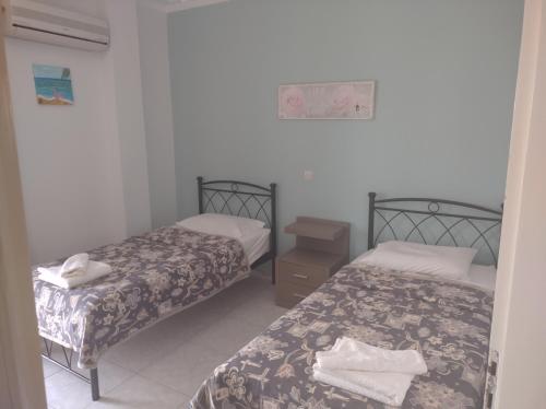 una camera con due letti e un comodino con asciugamani di Reggina's place a Cefalonia
