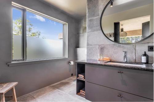 a bathroom with a sink and a mirror at Hvoll Villa in Ölfus