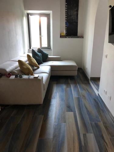 uma sala de estar com um sofá e pisos em madeira em Appartamento Katia Isola d'Elba em Portoferraio