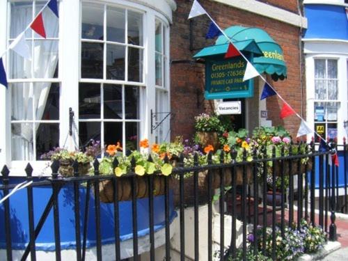 una cerca con un ramo de flores y un paraguas en Greenlands Guest House, en Weymouth