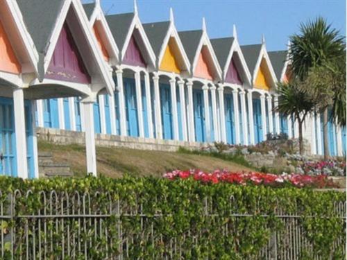 a row of houses with colorful roofs and flowers at Greenlands Guest House in Weymouth