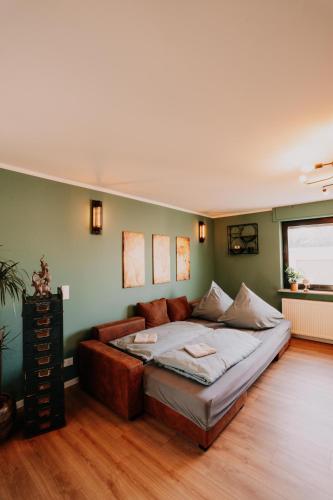 a bedroom with a large bed in a green wall at Ruhiges Soonwald Cottage in Dörrebach
