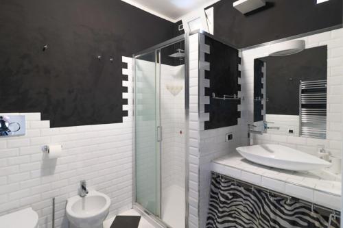 een badkamer met een wastafel en een glazen douche bij Bilocale accogliente tra Como e Milano in Saronno