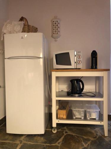 a white refrigerator next to a table with a microwave at Casa do Forno Évora retreat in Redondo