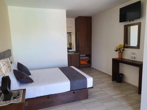 a hotel room with a bed and a television at Hotel Quinta Las Fuentes Bernal in Bernal