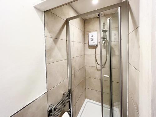 a shower with a glass door in a bathroom at Norbury House - Apartment 1A in Norbury