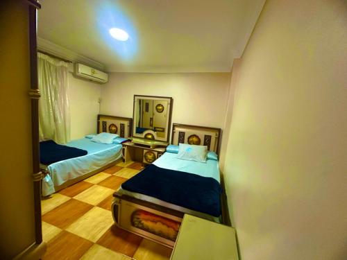 a small room with two beds and a mirror at Clara Apartment in Alexandria
