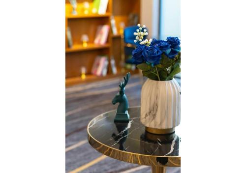 a table with a vase with blue flowers on it at فندق ياز in Taif