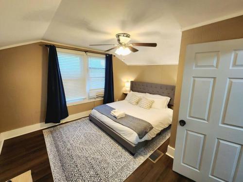 1 dormitorio con 1 cama, ventilador de techo y ventana en Magnolia House, en Lafayette