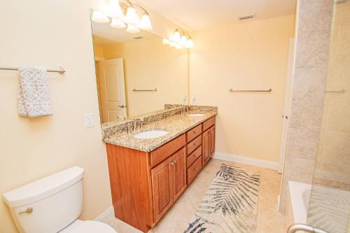 a bathroom with a sink and a toilet and a mirror at Lake Howard Hideway in Winter Haven