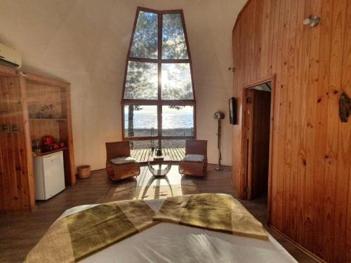 a bedroom with a bed and a large window at Magma Lodge, Pucon in Pucón