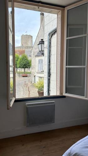 Schlafzimmer mit einem Fenster mit Straßenblick in der Unterkunft Appartement cœur de ville in Châtillon-sur-Indre