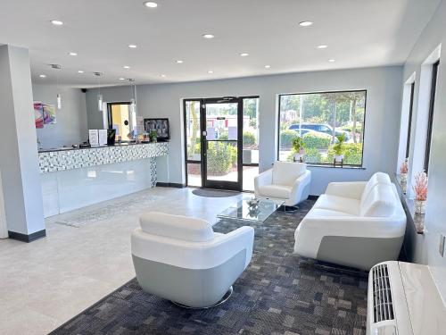 a large living room with white furniture and windows at Deluxe Inn - Fayetteville I-95 in Fayetteville