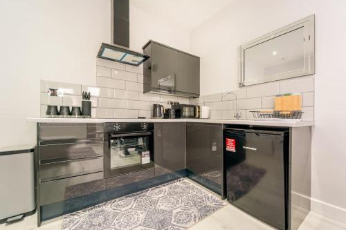 eine Küche mit einer schwarzen und weißen Arbeitsplatte in der Unterkunft Stylish 2Bedroom flat near train station in London in Seven Kings