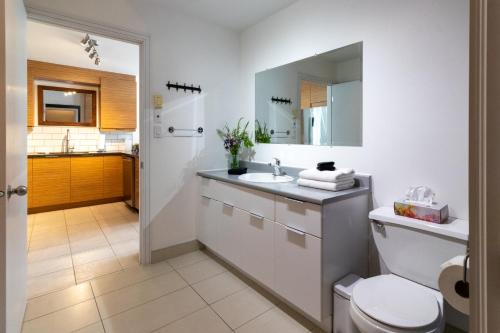 uma casa de banho branca com um lavatório e um WC em Détente Orford 111 condo/chalet em Orford