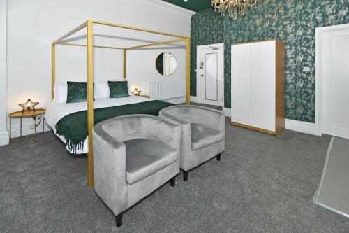 1 dormitorio con cama con dosel y silla en One Battison - Affordable Rooms, Suites & Studios in Stoke on Trent, en Stoke on Trent