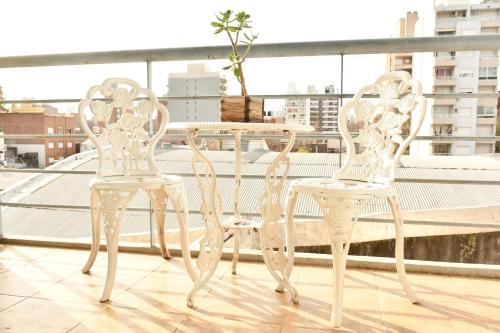 Dos sillas blancas y una mesa en un balcón. en tu dpto en ROSARIO, en Rosario