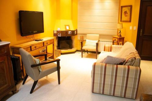 uma sala de estar com uma televisão, um sofá e uma cadeira em Casa Felice - Canela em Canela