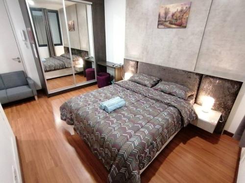 1 dormitorio con 1 cama grande y espejo en i-Duplex Condo - LED Garden, Fun Fair, Wax Museum, Waterpark, Mall & More!, en Shah Alam