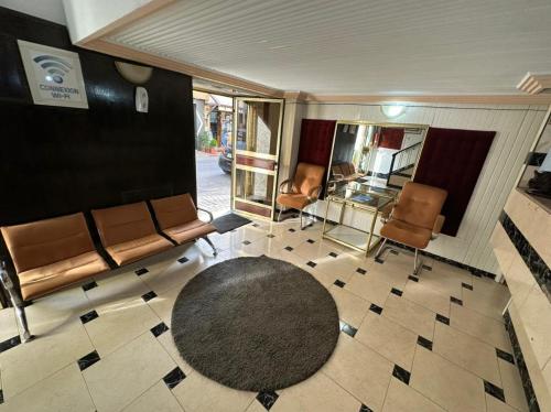 Zimmer mit Stühlen, einem Tisch und einem Teppich in der Unterkunft Hôtel National in Al Hoceïma