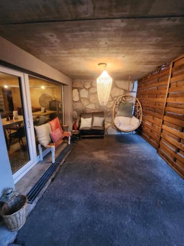 einen Flur mit Stühlen und einem Kronleuchter in einem Haus in der Unterkunft Chez Pipo in Conthey