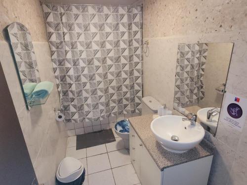 Baño pequeño con lavabo y aseo en HOSTAL PARADISE BLUE OSORNO, en Osorno