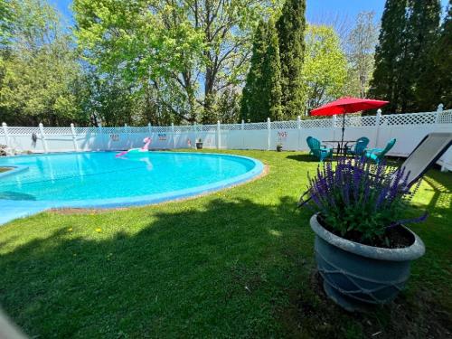 un patio con piscina con sombrilla roja en Claddagh Motel & Suites, en Rockport