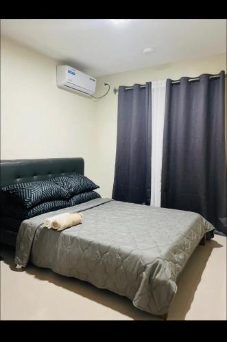 uma cama num quarto com uma cortina preta em Cozy and Spacious With a view and parking em Antipolo