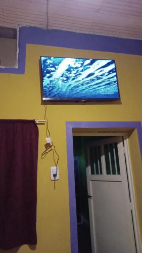 TV de pantalla plana en una pared sobre una puerta en Apart Chuspita en Humahuaca