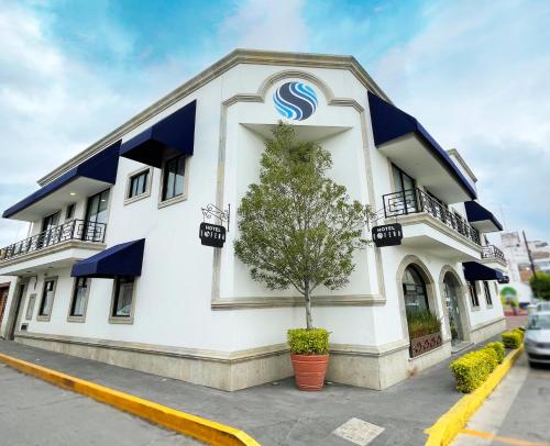 a large white building with blue balconies at Hotel Esfera Tulancingo in Tulancingo
