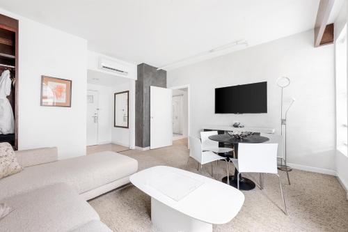 a white living room with a couch and a table at The O Hotel, Trademark Collection by Wyndham in Los Angeles