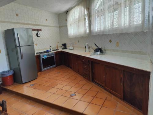 a kitchen with a refrigerator and a tile floor at Villa Isabel in Tangolunda