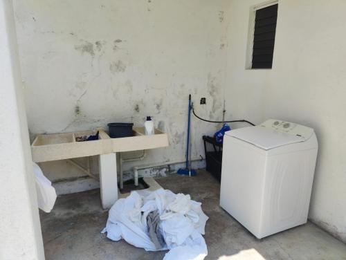 タンゴルンダにあるVilla Isabelの白い冷蔵庫とテーブルが備わる汚い部屋