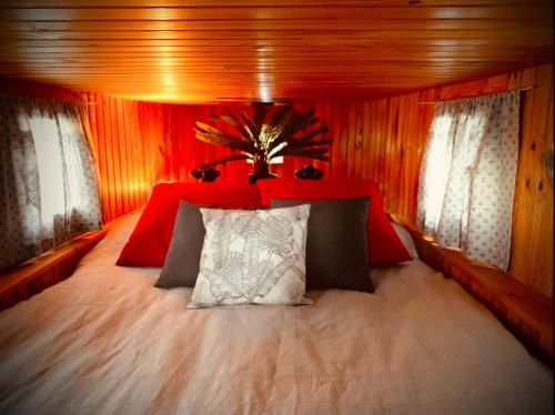 um quarto com uma cama grande e uma cabeceira vermelha em Magnifique péniche remorqueur à louer em Évran