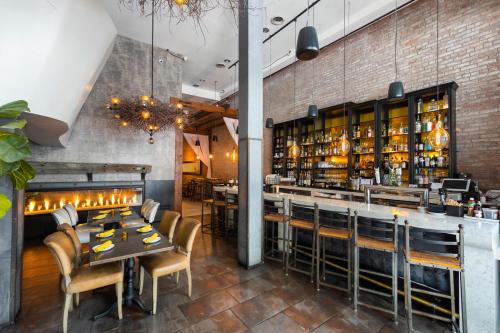 a restaurant with a table and chairs and a bar at O Hotel by LuxUrban, Trademark Collection by Wyndham in Los Angeles