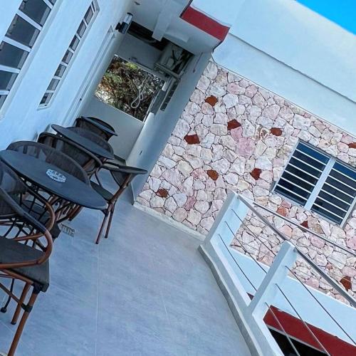 an outdoor patio with tables and a stone wall at Boca Simon Vacation Curacao in Willemstad