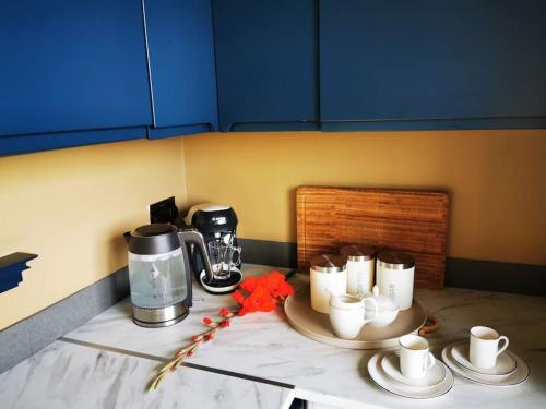 a counter with coffee cups and a coffee maker on it at Luxury Apartment Brighton and South Downs National Park, Free Parking in Falmer