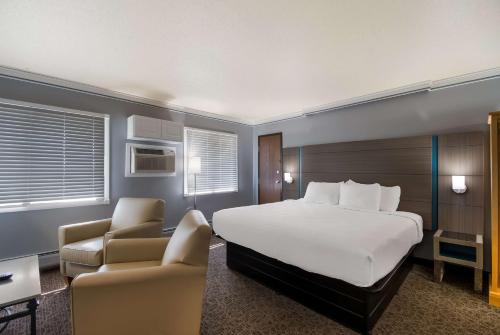 a hotel room with a bed and two chairs at Best Western Bemidji in Bemidji