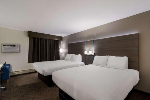 two beds in a hotel room with white sheets at Best Western Bemidji in Bemidji