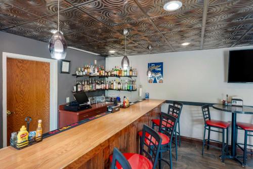 a bar with red chairs and a wooden counter at Best Western Plus Eau Claire Conference Center in Eau Claire